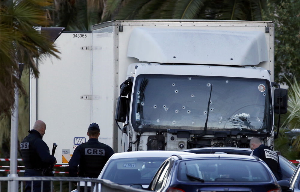 French CRS and judicial police work near the heavy truck that ran into a crowd at high speed celebrating the Bastille Day July 14 national holiday on the Promenade des Anglais killing 80 people in Nice, France, July 15, 2016. REUTERS/Eric Gaillard