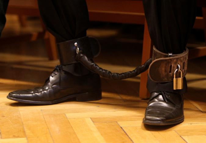 The feet of Syrian-Cypriot Ahmed Hamed, 40, are chained together as he listens to a judge sentence him for 10 years in jail for his part in a 2015 riot at Hungary's Serbian border in Szeged, Hungary, November 30, 2016. Reuters/Bernadett Szabo